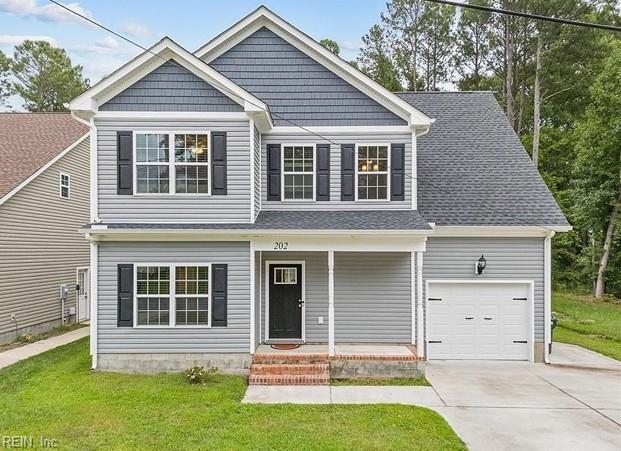 view of front of house featuring covered porch, a garage, a front lawn, and concrete driveway