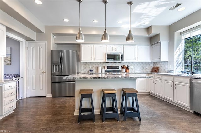 kitchen featuring white cabinetry, a sink, stainless steel appliances, and dark wood-style floors