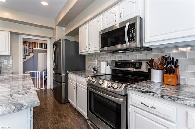 kitchen featuring white cabinetry, stainless steel appliances, and light stone counters