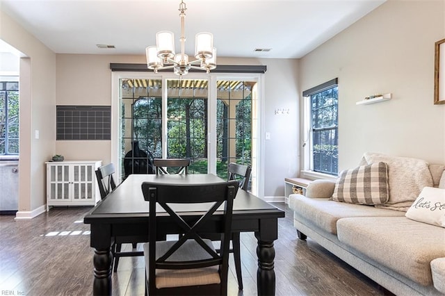 dining room featuring baseboards, dark wood-style flooring, visible vents, and a notable chandelier