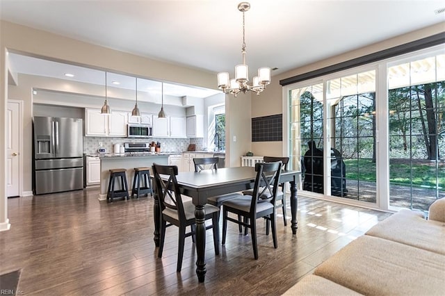 dining room with dark wood finished floors, baseboards, visible vents, and an inviting chandelier