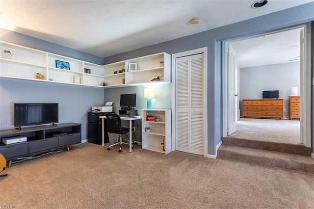 carpeted office featuring baseboards and a textured ceiling