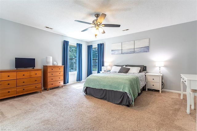 bedroom with visible vents, carpet, and a textured ceiling