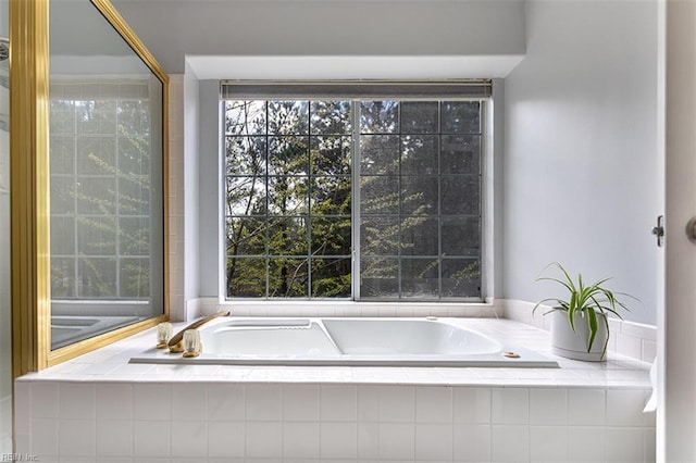 full bathroom featuring a garden tub and a healthy amount of sunlight