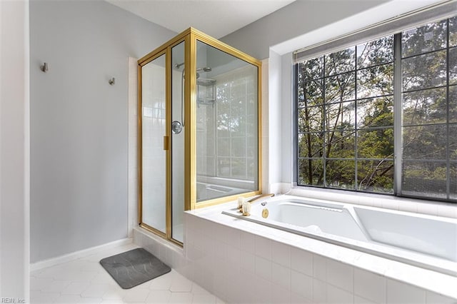 full bathroom featuring tile patterned floors, a bath, baseboards, and a shower stall