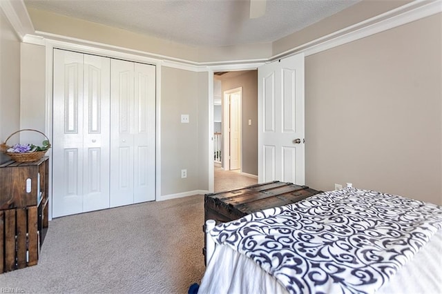 carpeted bedroom featuring a closet, ceiling fan, and a textured ceiling