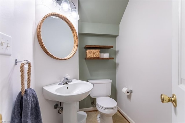 bathroom featuring toilet, tile patterned flooring, and baseboards