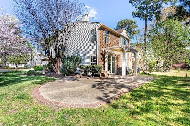 rear view of property featuring a lawn, a pergola, a patio area, and a chimney