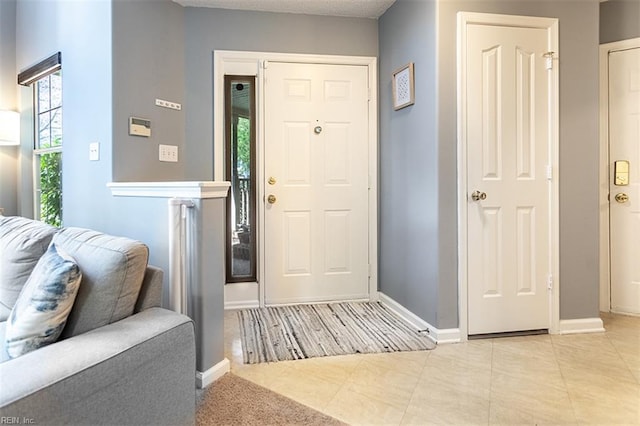 tiled foyer featuring baseboards