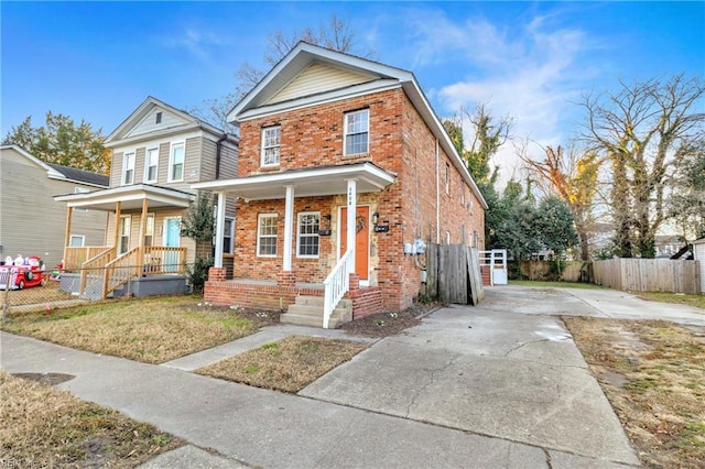 1438 Lasalle Ave, Portsmouth, VA 23704 - traditional-style home featuring fence, a front yard, brick siding, driveway, and covered porch