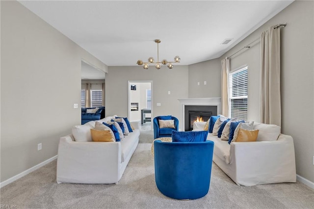 carpeted living room featuring baseboards, a glass covered fireplace, and visible vents