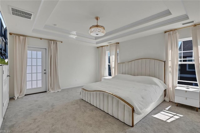bedroom with visible vents, a tray ceiling, ornamental molding, and carpet floors