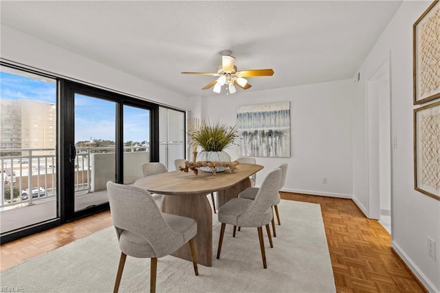 dining area featuring a ceiling fan and baseboards