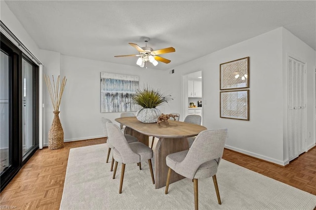 dining space with a ceiling fan, baseboards, and a healthy amount of sunlight