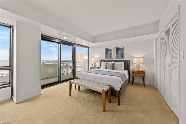 bedroom featuring baseboards, light carpet, multiple windows, and access to exterior