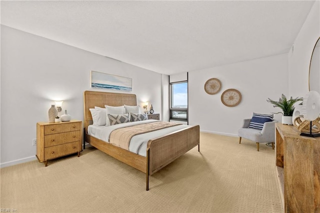 bedroom with baseboards and light carpet