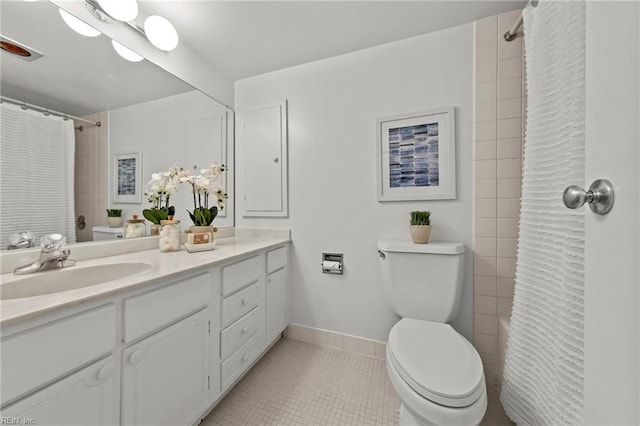 bathroom featuring toilet, tile patterned floors, baseboards, and vanity