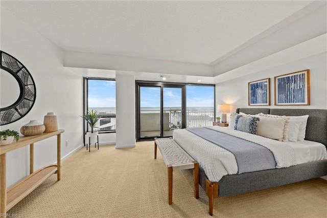 bedroom with light colored carpet, baseboards, and access to exterior
