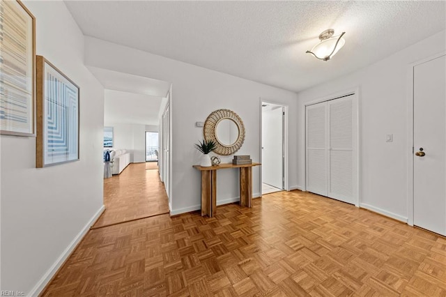 entryway with baseboards and a textured ceiling