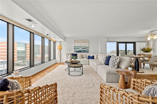living room featuring a ceiling fan and visible vents