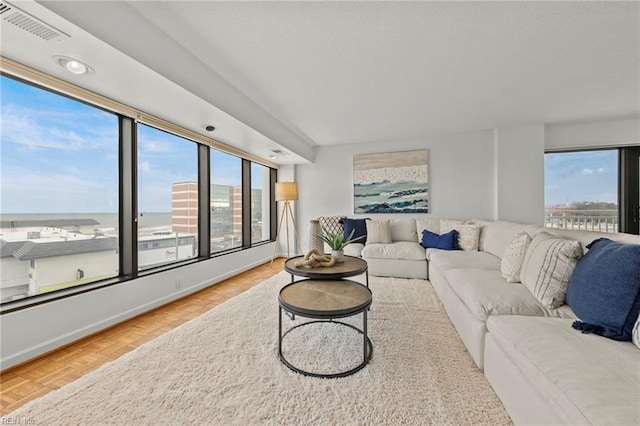 living area with baseboards and visible vents