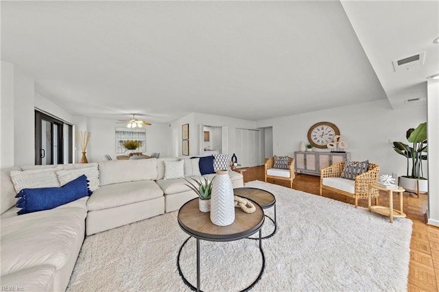 living area with ceiling fan and visible vents