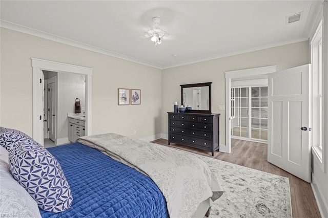 bedroom with baseboards, visible vents, ornamental molding, and wood finished floors