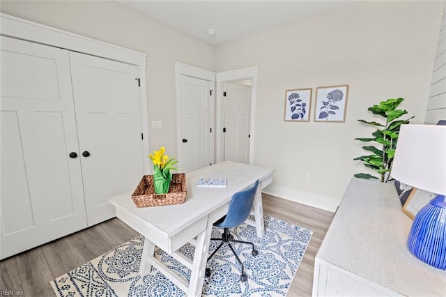 office space with baseboards and light wood-style floors