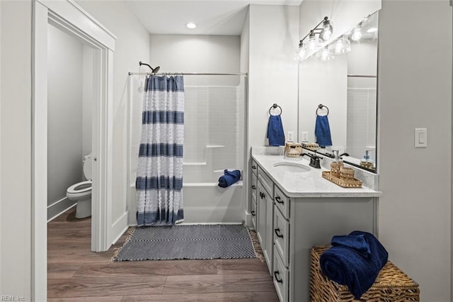 full bath with shower / bath combination with curtain, wood finished floors, toilet, and vanity