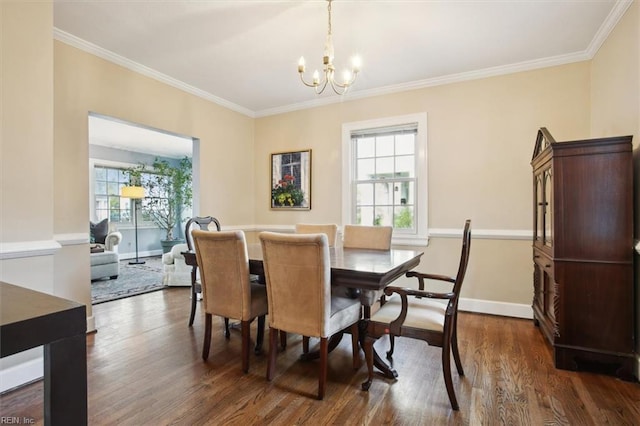 dining area featuring dark wood finished floors, ornamental molding, and an inviting chandelier