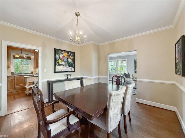 dining space with baseboards, wood finished floors, a notable chandelier, and plenty of natural light