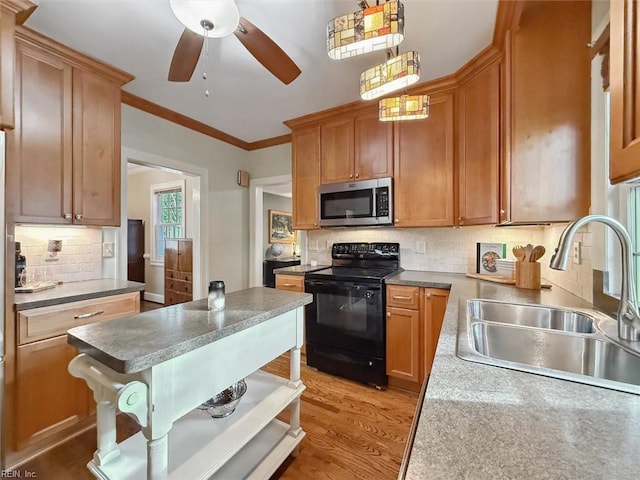 kitchen with ornamental molding, stainless steel microwave, black range with electric cooktop, a sink, and light wood-type flooring