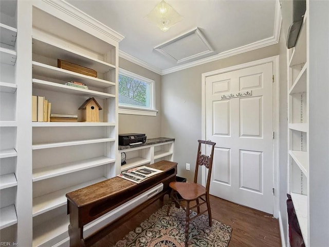 living area featuring attic access, wood finished floors, and ornamental molding