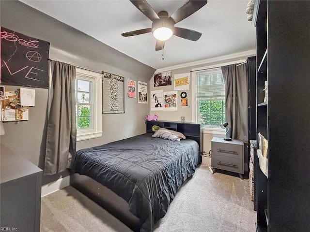 bedroom featuring light carpet, multiple windows, and ceiling fan