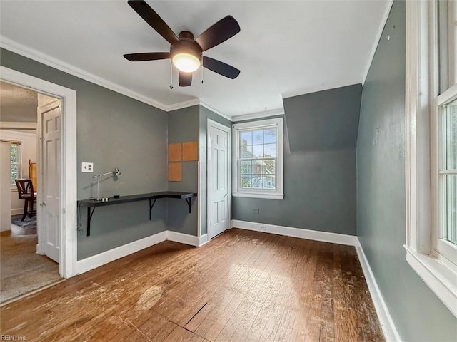 empty room with baseboards, ceiling fan, ornamental molding, and hardwood / wood-style floors