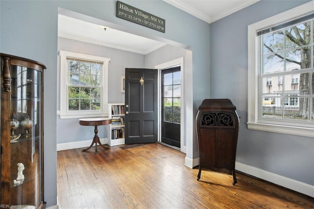 foyer entrance with baseboards, ornamental molding, and wood-type flooring