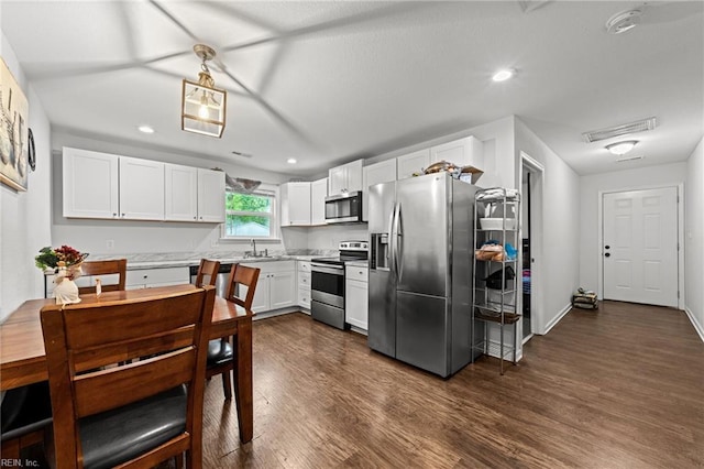 kitchen featuring dark wood-type flooring, light countertops, white cabinets, and stainless steel appliances