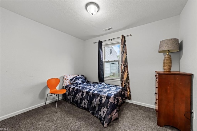 bedroom featuring carpet, visible vents, a textured ceiling, and baseboards