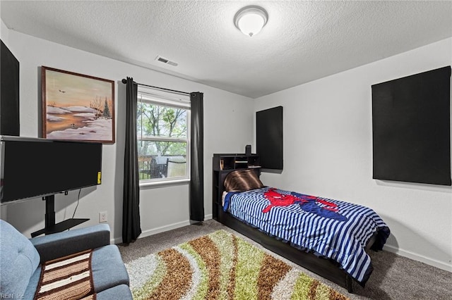 bedroom featuring carpet, visible vents, a textured ceiling, and baseboards