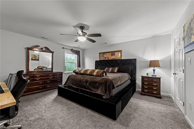 carpeted bedroom with visible vents, a textured ceiling, and ceiling fan