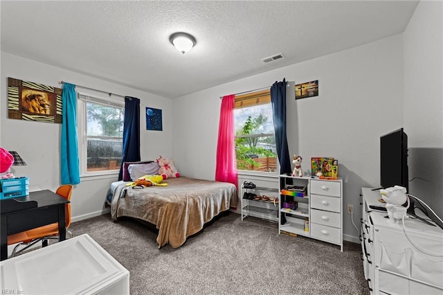bedroom with visible vents, baseboards, carpet floors, and a textured ceiling