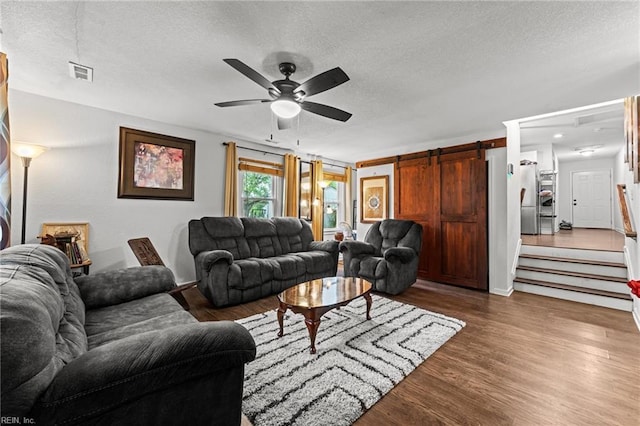 living room featuring visible vents, dark wood finished floors, and a textured ceiling