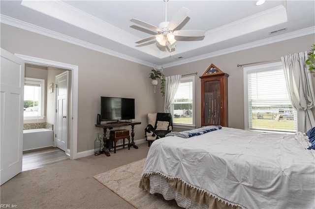 carpeted bedroom with a raised ceiling, ornamental molding, multiple windows, and visible vents