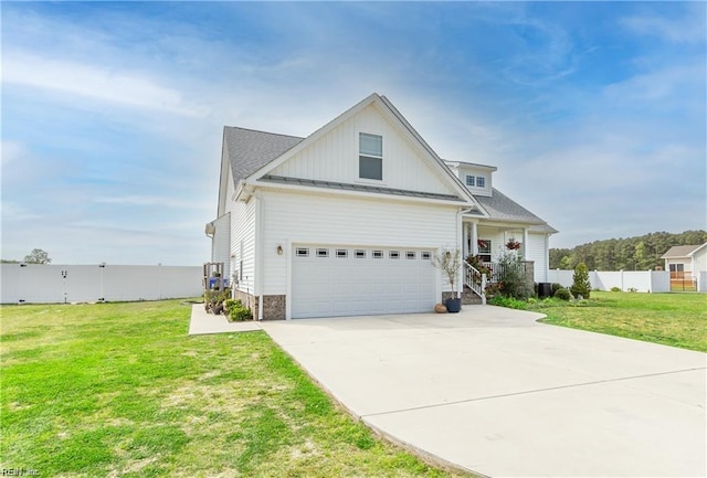 view of front of property with driveway, a standing seam roof, fence, board and batten siding, and a front lawn