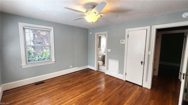 unfurnished bedroom featuring hardwood / wood-style floors, baseboards, a textured ceiling, ceiling fan, and ensuite bathroom