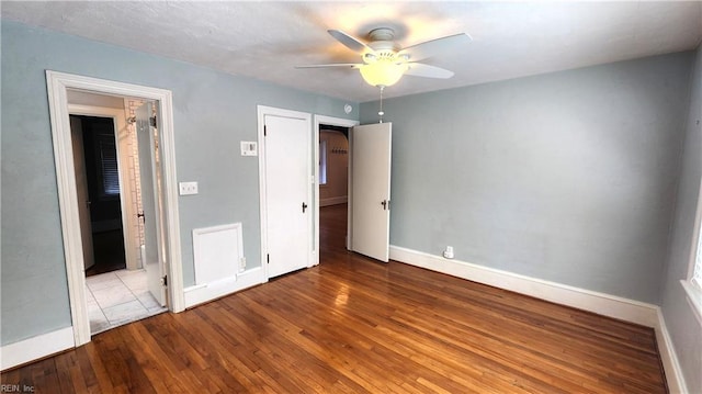 unfurnished bedroom with wood-type flooring, baseboards, and ceiling fan