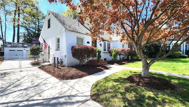 view of front of house featuring an outbuilding, fence, and a front lawn