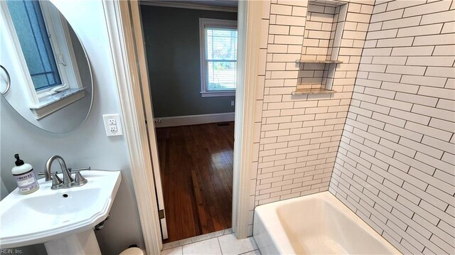 full bath with baseboards, tub / shower combination, tile patterned flooring, and a sink