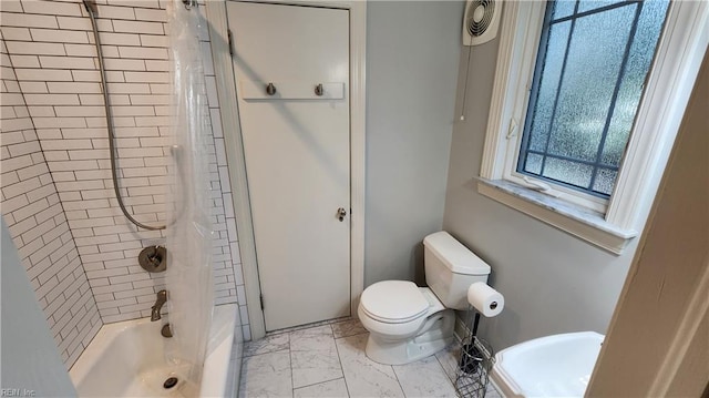 bathroom featuring marble finish floor, shower / bath combination, and toilet