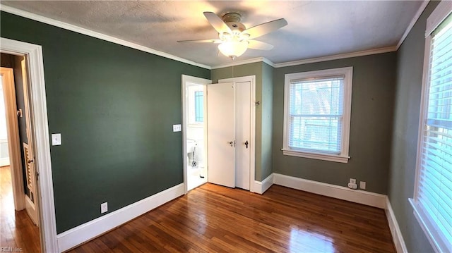 unfurnished bedroom featuring a closet, ornamental molding, baseboards, and wood finished floors